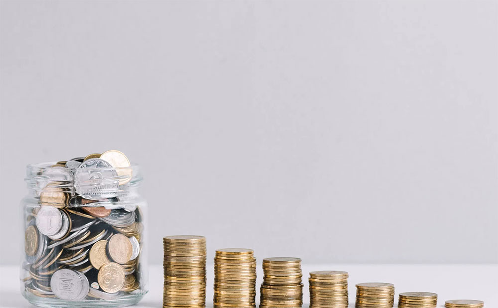 u.s. coins in a clear jar next to stacks of quarters