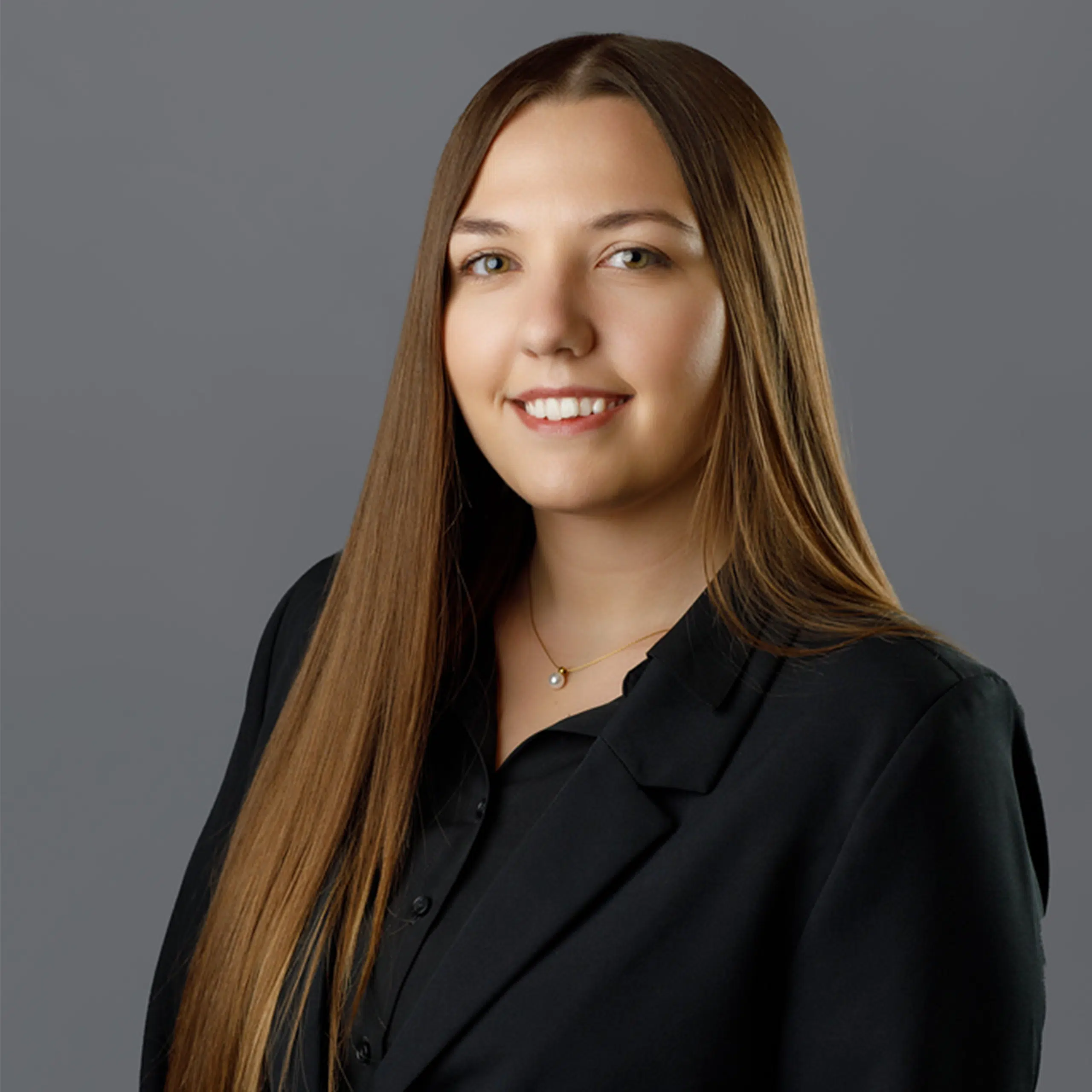 Haley Turk smiling in a suit coat with a grey background